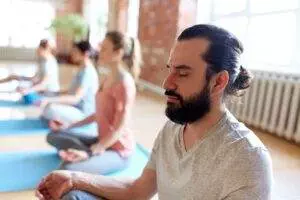 Man meditating in group yoga