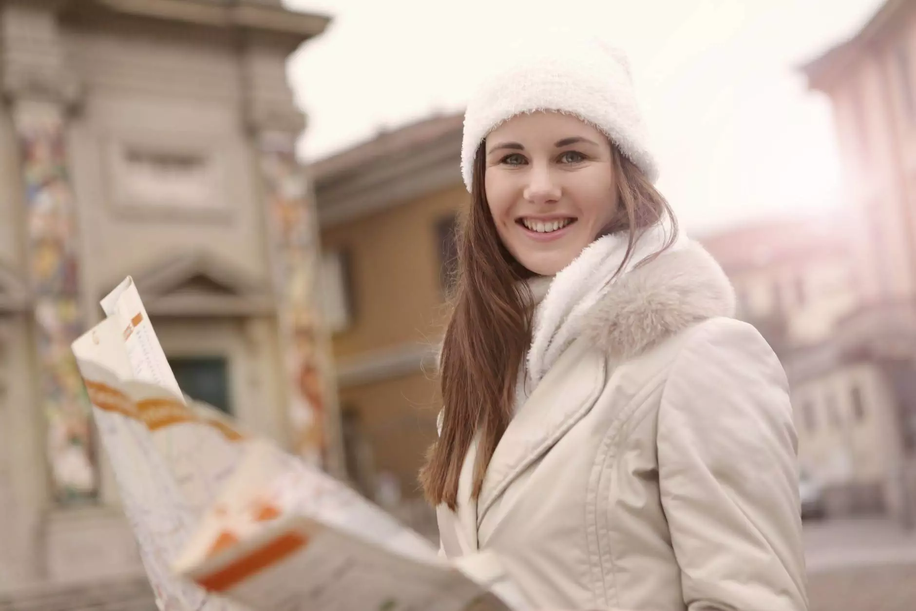 happy young woman with map smiling in street